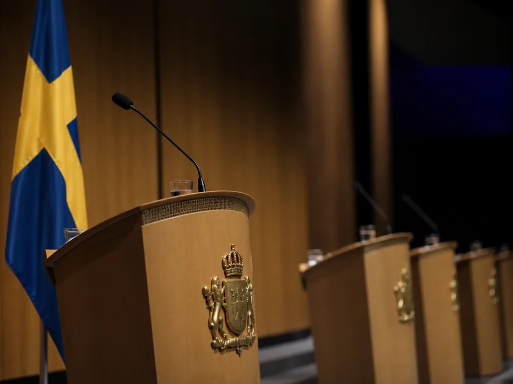 Tom debattscen med Sveriges flagga och mikrofon inför en partiledardebatt